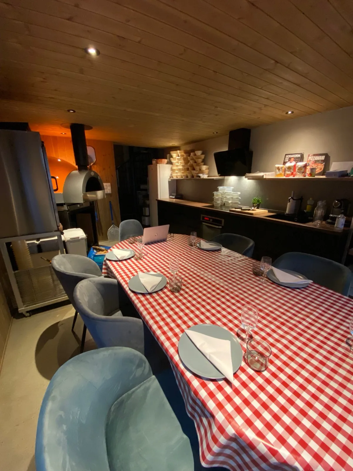 Kurslokalet med langbord og vedfyrt ovn klart til hyggekveld hos Landøy Brød & Pizza i Mandal