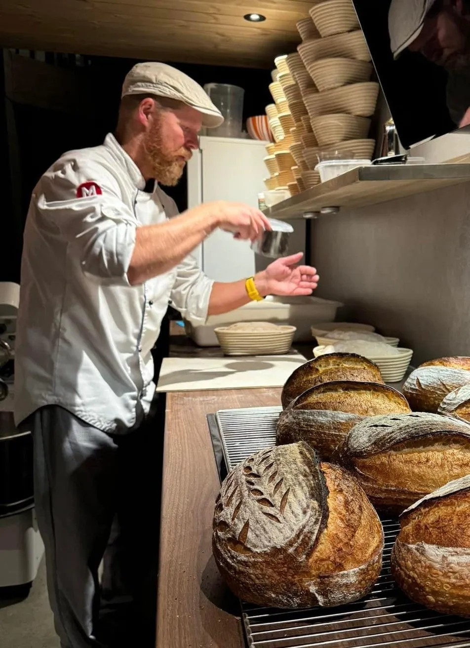 Trond Skogvoll med nybakte surdeigsbrød på rist hos Landøy Brød & Pizza i Mandal