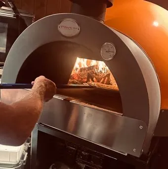 Levende flammer i den vedfyrte pizzaovnen hos Landøy Brød & Pizza i Mandal